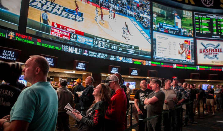 A bunch of people hanging together awaiting sports bets results.